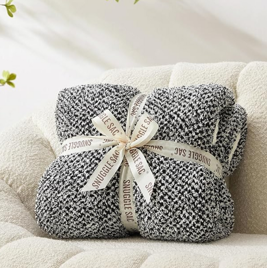 Reversible Heather Black Snuggle Sac twin blanket displayed on a sofa or bed.